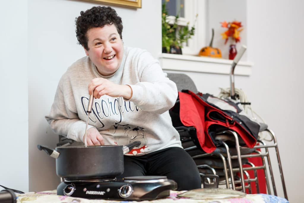 Happy woman pouring soup