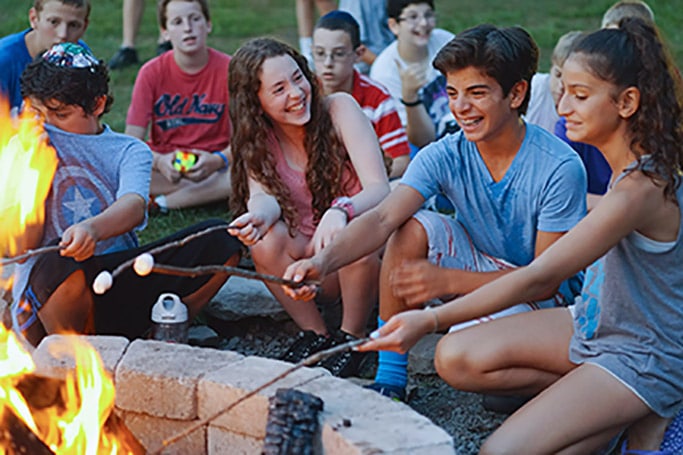 Children at camp roasting marshmallows