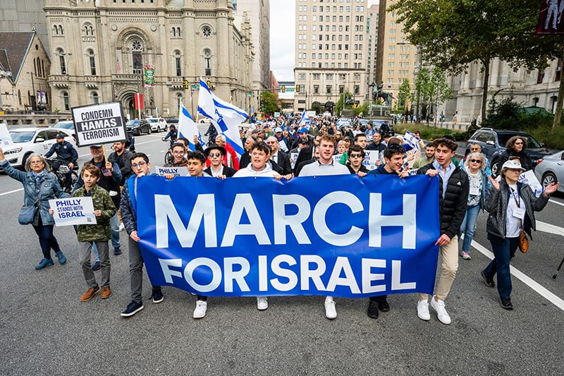 People marching with a March For Israel sign